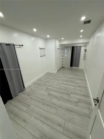 a large white room with wooden floor