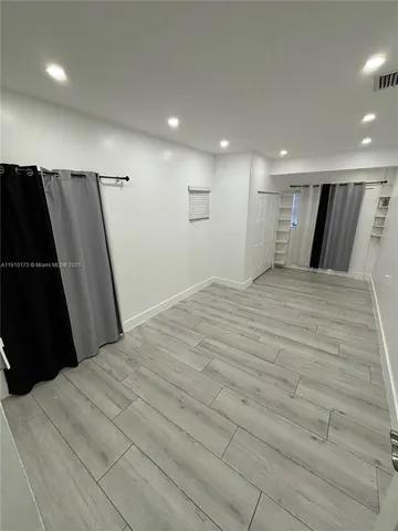 a large bedroom with a bed and a walk in closet