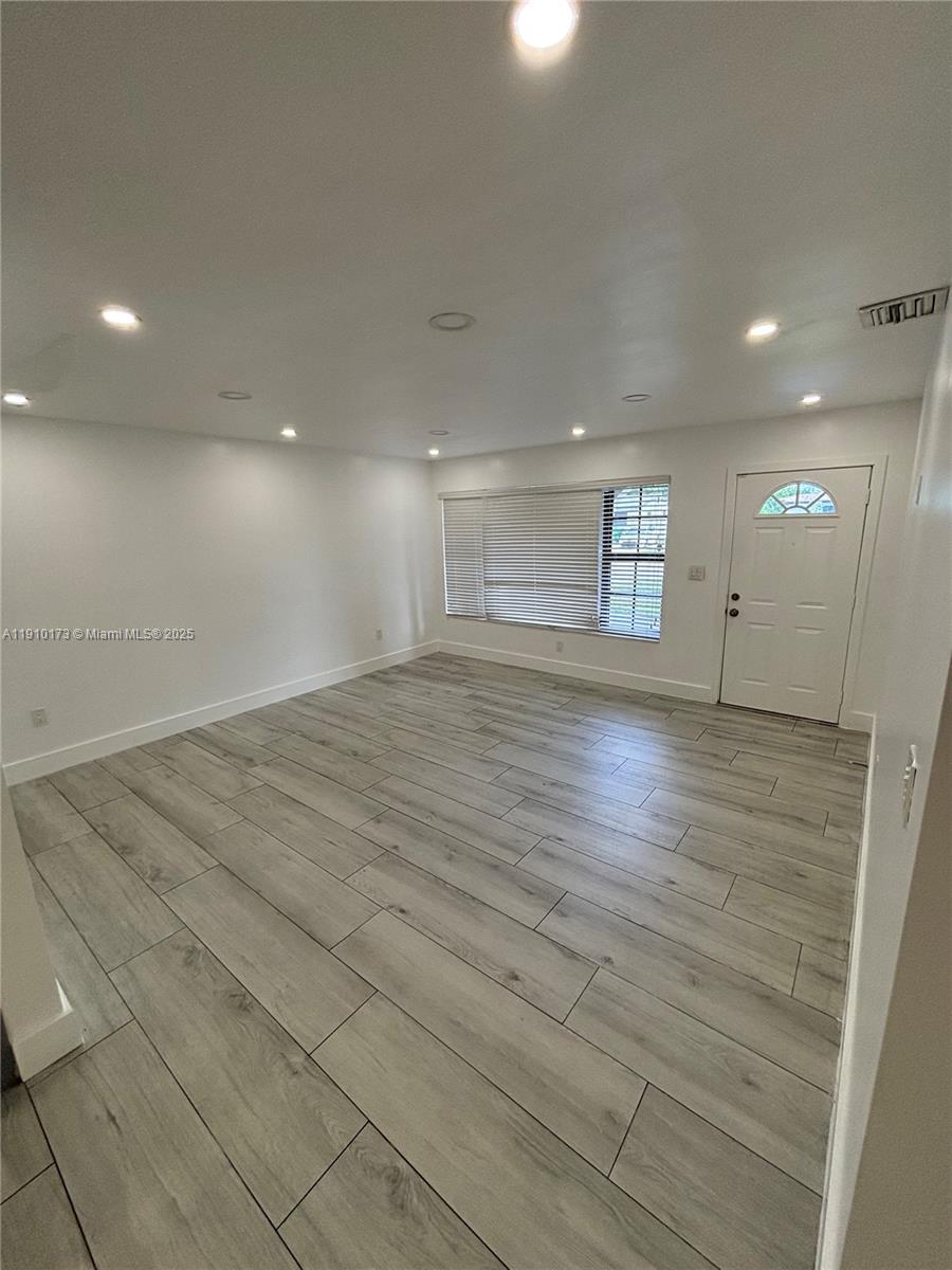 17110 Northwest 11th Avenue Miami Gardens, FL 33169 - Photo 3 of 38 an empty room with wooden floor and windows