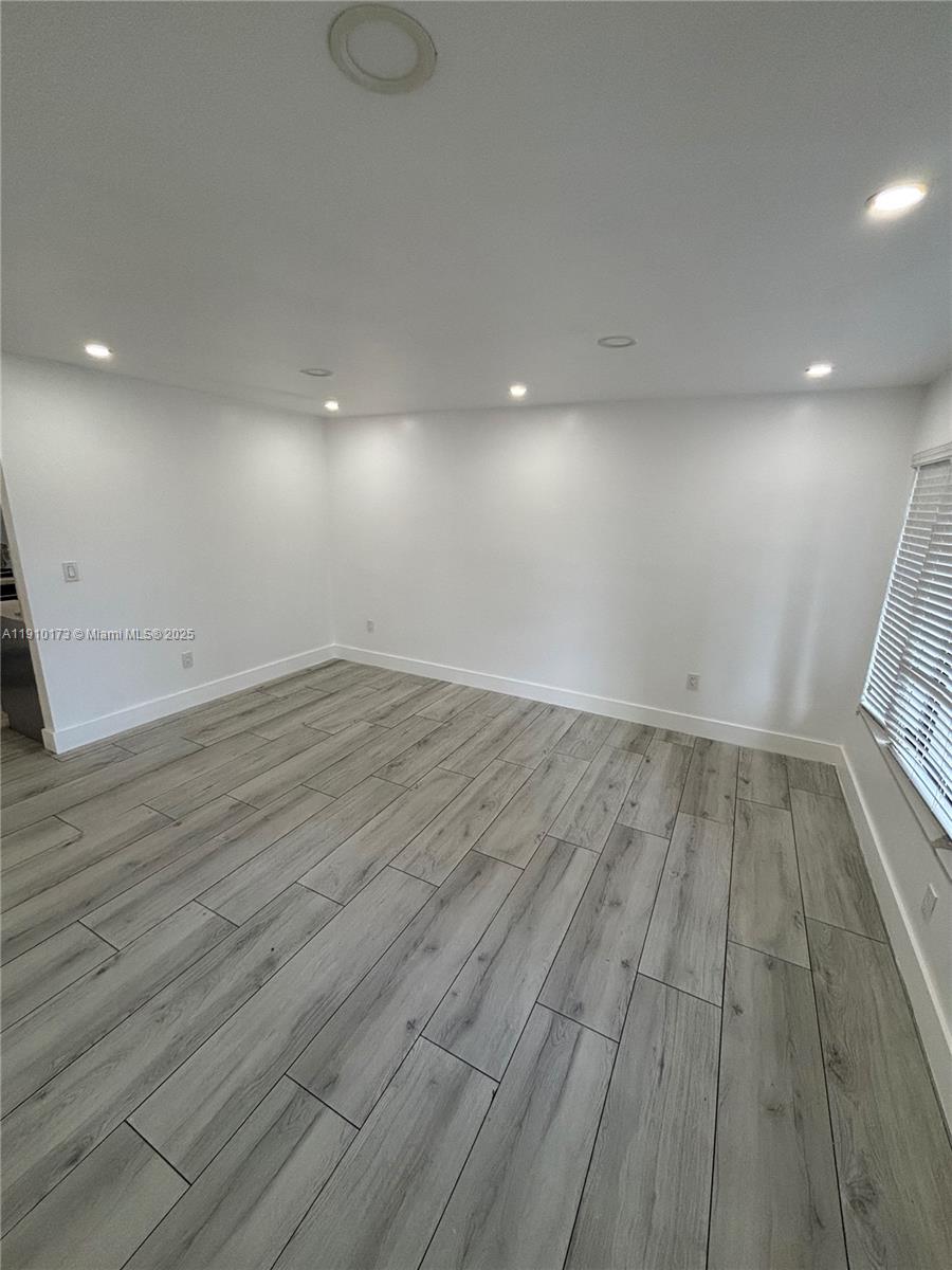 17110 Northwest 11th Avenue Miami Gardens, FL 33169 - Photo 5 of 38 an empty room with wooden floor and windows