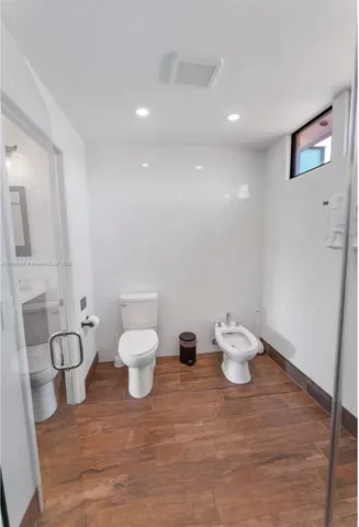 a bathroom with a toilet a sink and a mirror