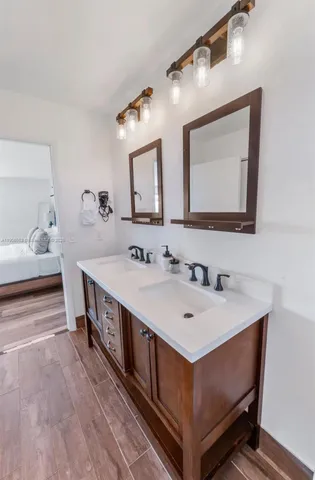 a en suite bathroom with a double vanity sink and a mirror
