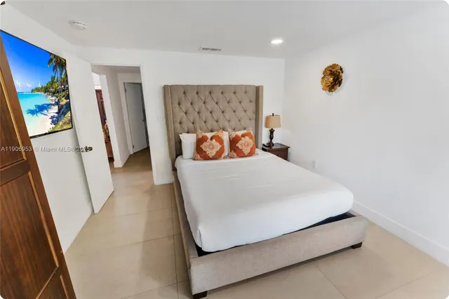 a bed sitting in a bedroom next to a window