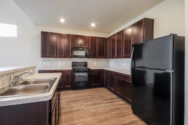 a kitchen with a refrigerator sink and wooden cabinets