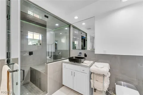 a bathroom with a granite countertop sink a mirror and shower