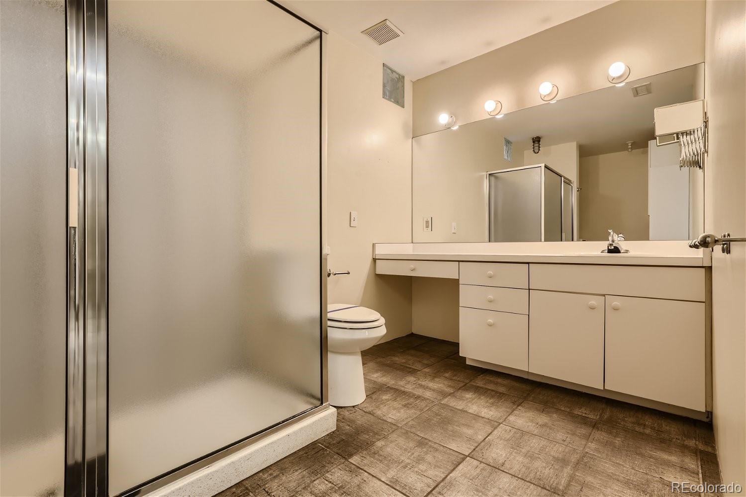 3349 Blake Street Denver, CO 80205 - Photo 22 of 28 a bathroom with a double vanity sink toilet and shower