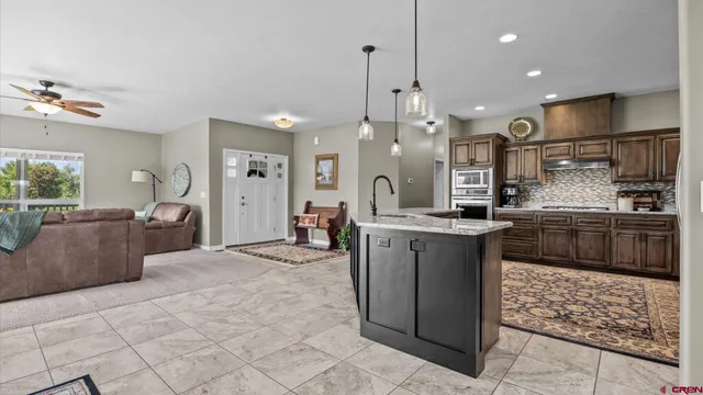 a kitchen with stainless steel appliances granite countertop a stove a sink and a refrigerator