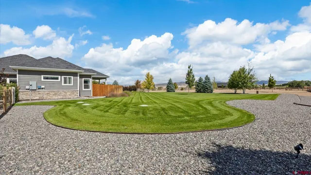 a view of a backyard with table and chairs under an umbrella
