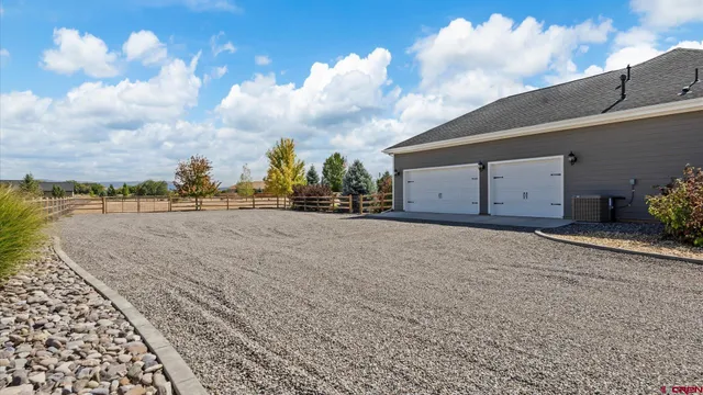 a view of an house with a big yard and potted plants