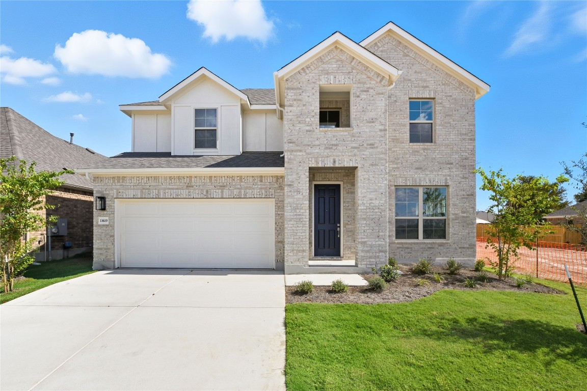 a front view of a house with a yard and garage