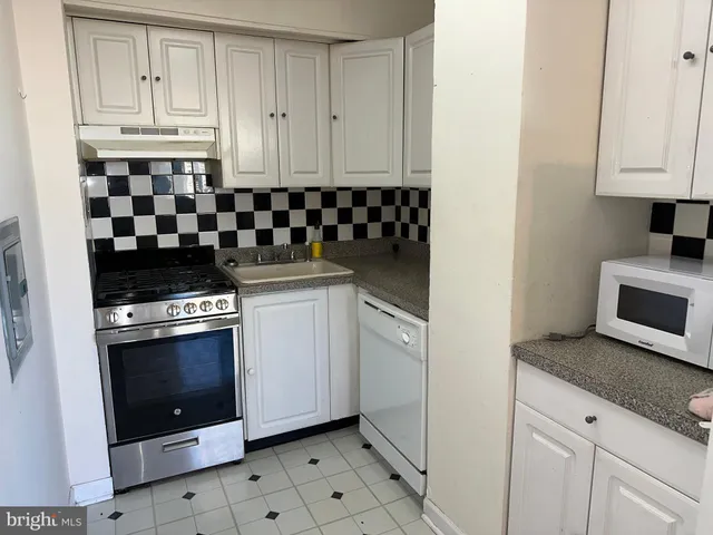 a kitchen with granite countertop white cabinets and stainless steel appliances