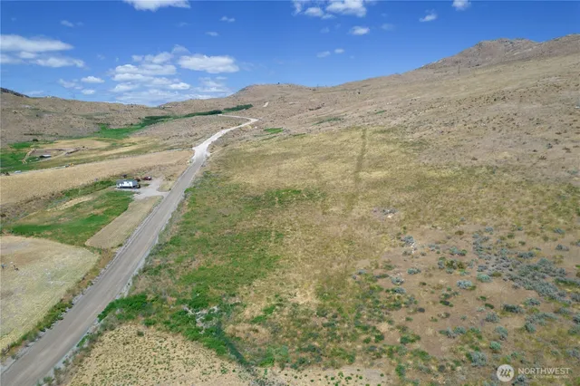a view of a dry yard with mountains in the background