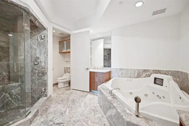 a large white bathroom with a sink a large mirror and a bathtub