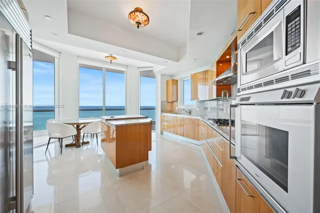 a large white kitchen with granite countertop a sink and a stove