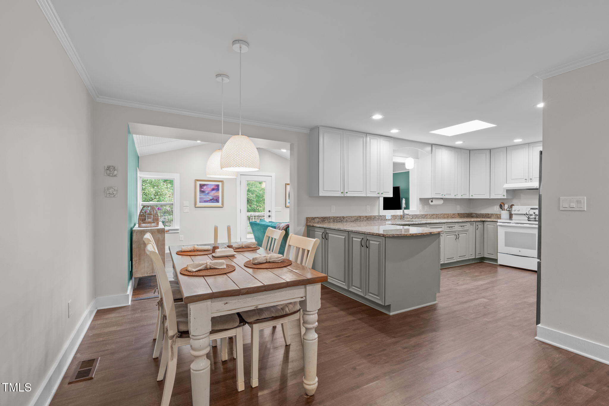 7304 St Ledger Drive Raleigh, NC 27613 - Photo 7 of 29 a kitchen with a table chairs a sink dishwasher window and cabinets