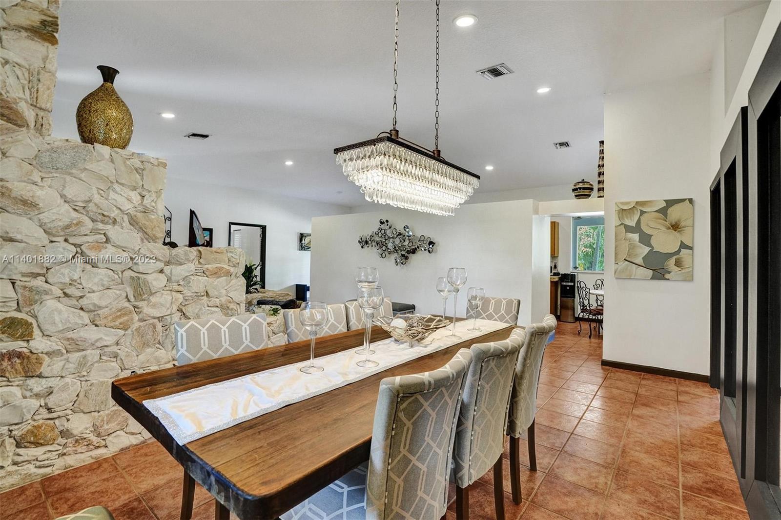 15971 Southwest 252nd Street Homestead, FL 33031 - Photo 17 of 92 a dining room with wooden floor a chandelier a wooden table and chairs