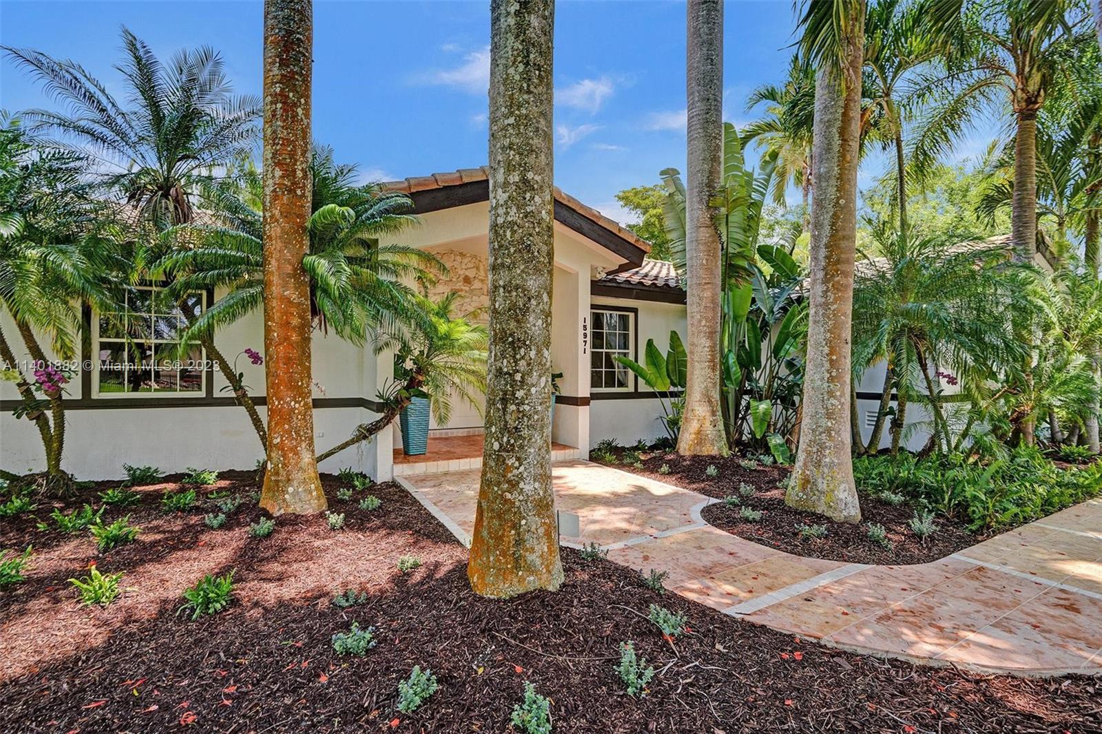 15971 Southwest 252nd Street Homestead, FL 33031 - Photo 3 of 92 a front view of a house with a yard and potted plants