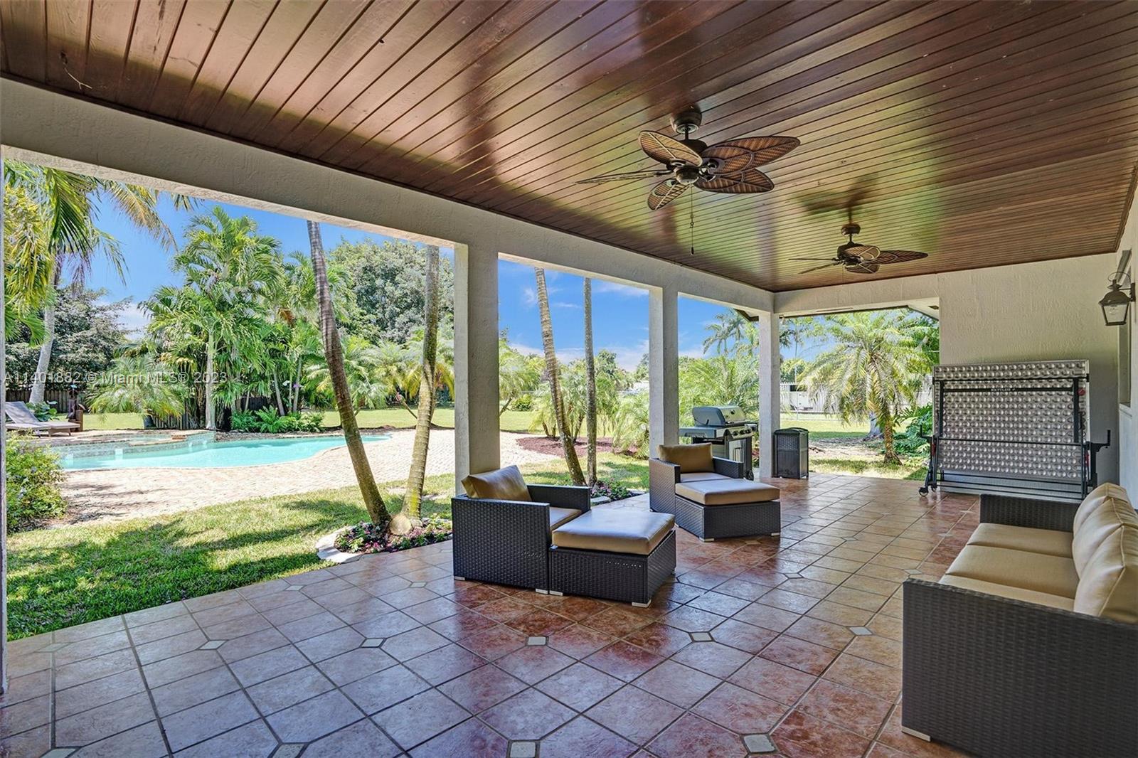 15971 Southwest 252nd Street Homestead, FL 33031 - Photo 52 of 92 a living room with patio furniture and a floor to ceiling window