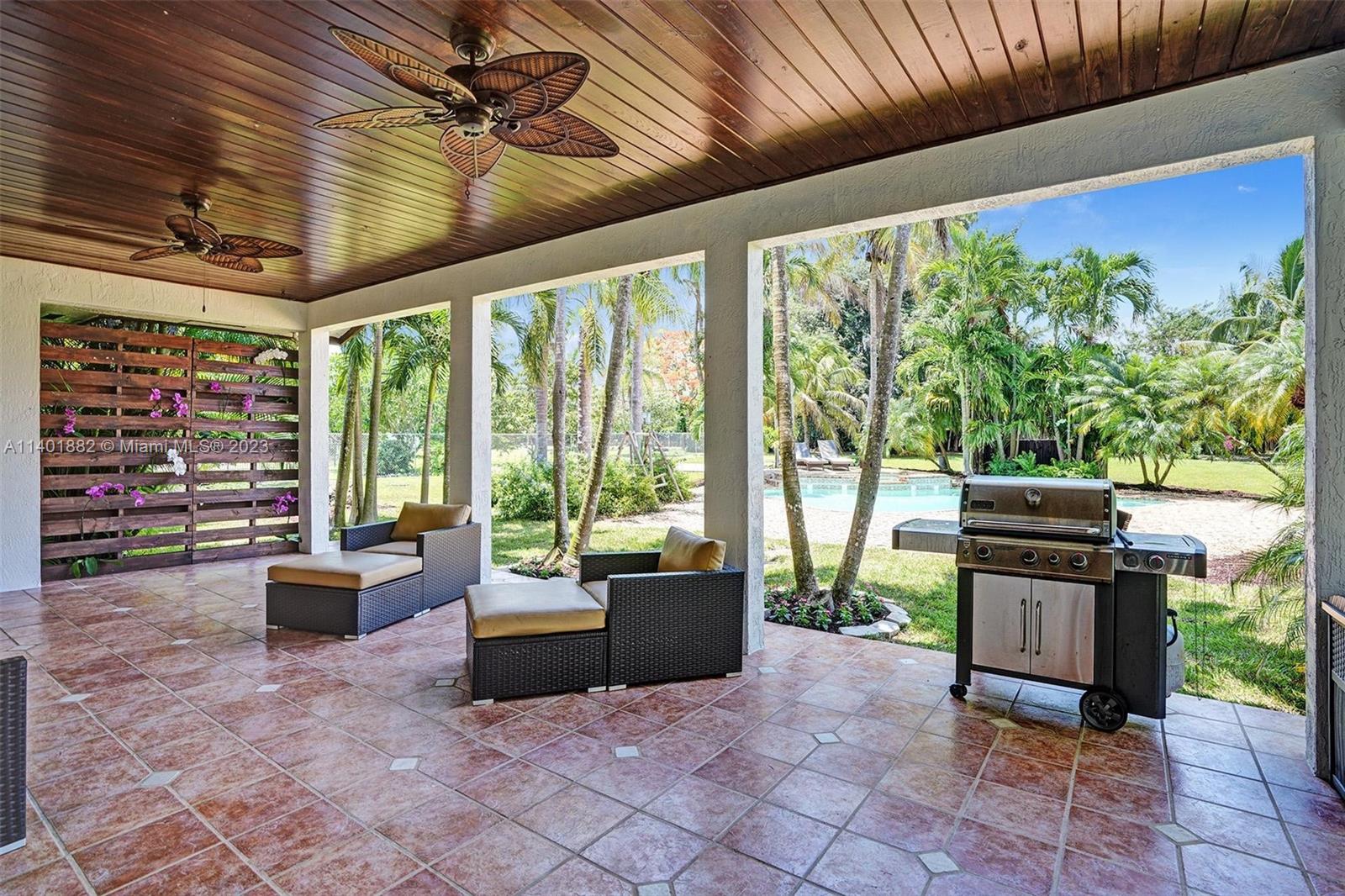 15971 Southwest 252nd Street Homestead, FL 33031 - Photo 55 of 92 a living room with furniture and a flat screen tv