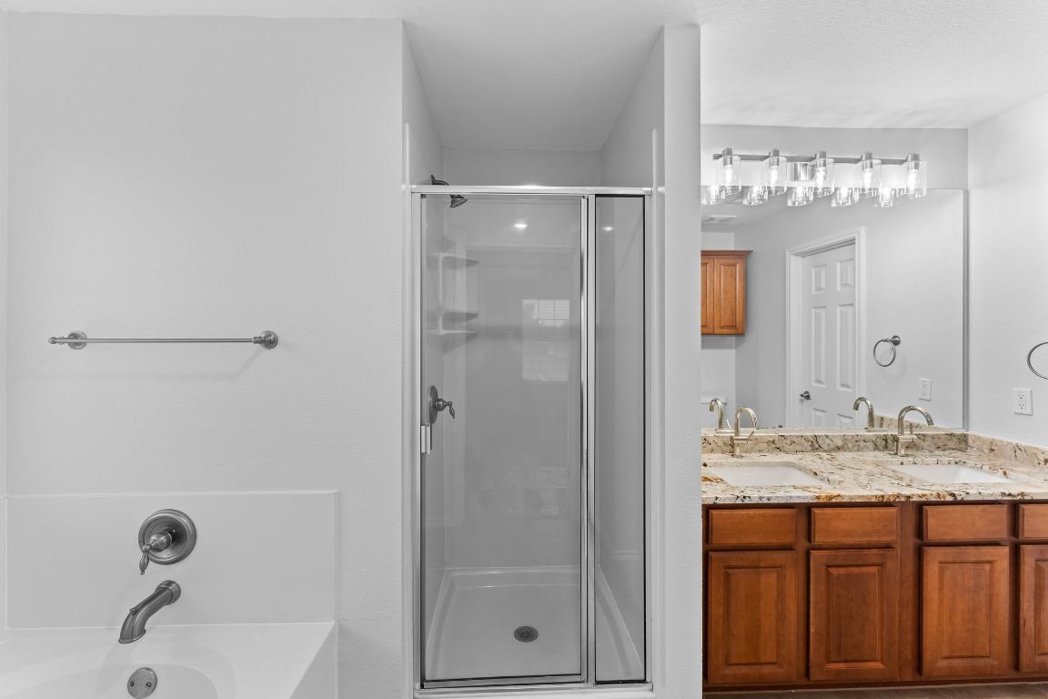 292 Housefinch Loop Leander, TX 78641 - Photo 17 of 29 Bathroom with a shower stall, a garden tub, and double vanity