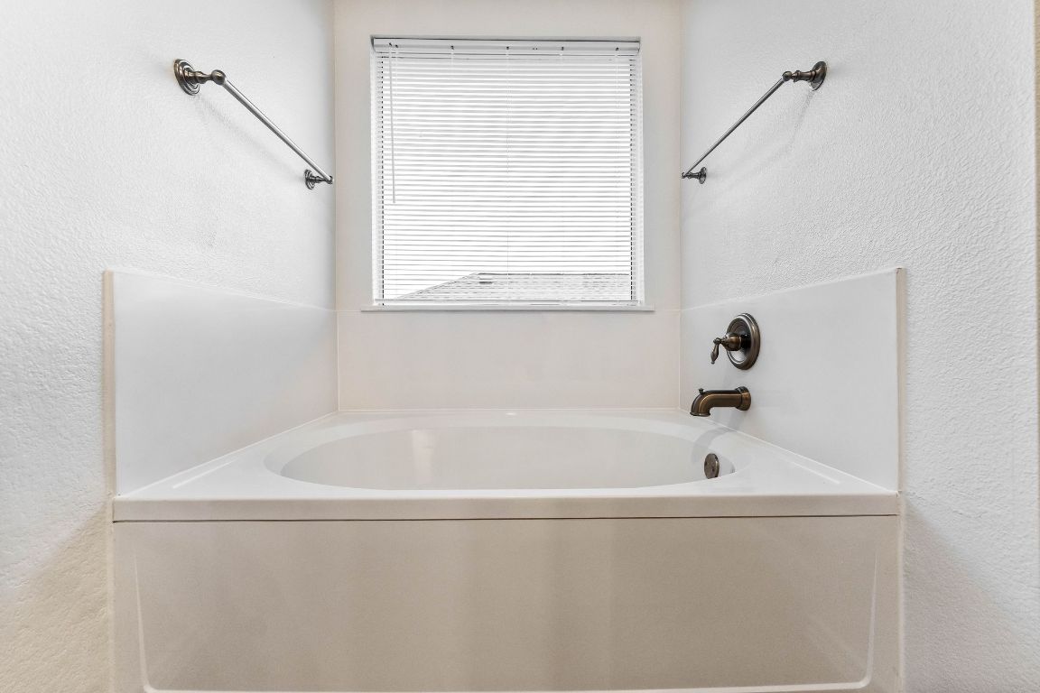 292 Housefinch Loop Leander, TX 78641 - Photo 20 of 29 Bathroom featuring a garden tub and a textured wall