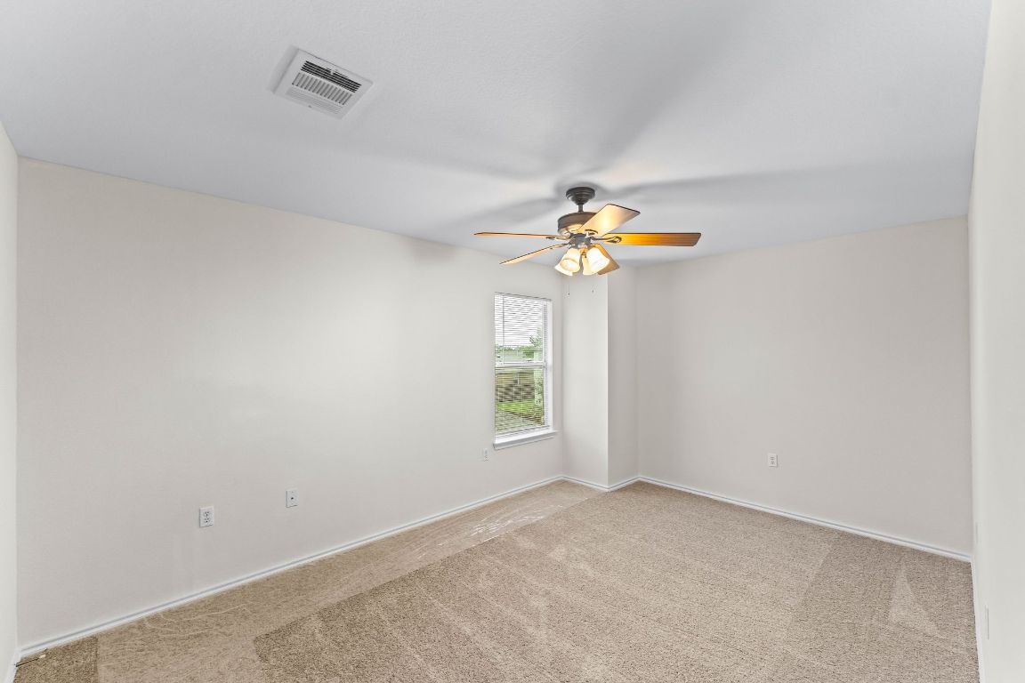 292 Housefinch Loop Leander, TX 78641 - Photo 24 of 29 Carpeted empty room featuring a ceiling fan and baseboards