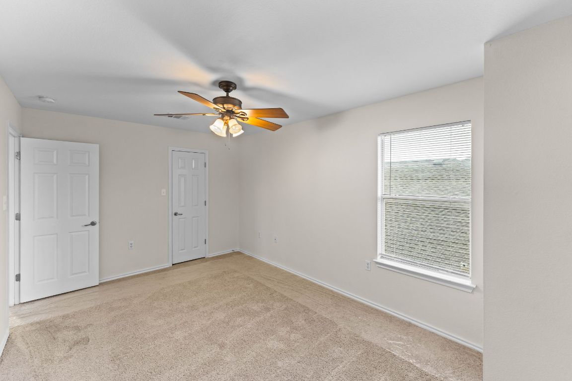 292 Housefinch Loop Leander, TX 78641 - Photo 26 of 29 Unfurnished bedroom featuring carpet flooring and a ceiling fan