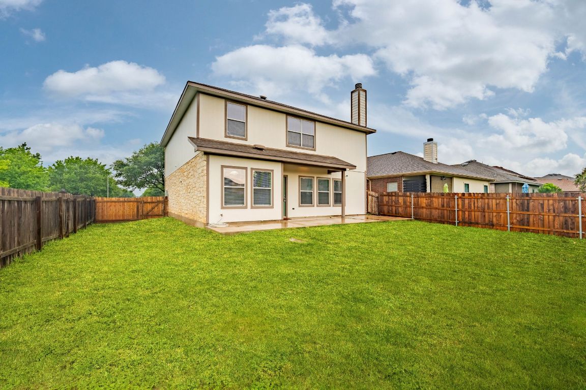 292 Housefinch Loop Leander, TX 78641 - Photo 28 of 29 Back of house featuring a chimney, a fenced backyard, a patio, and stucco siding