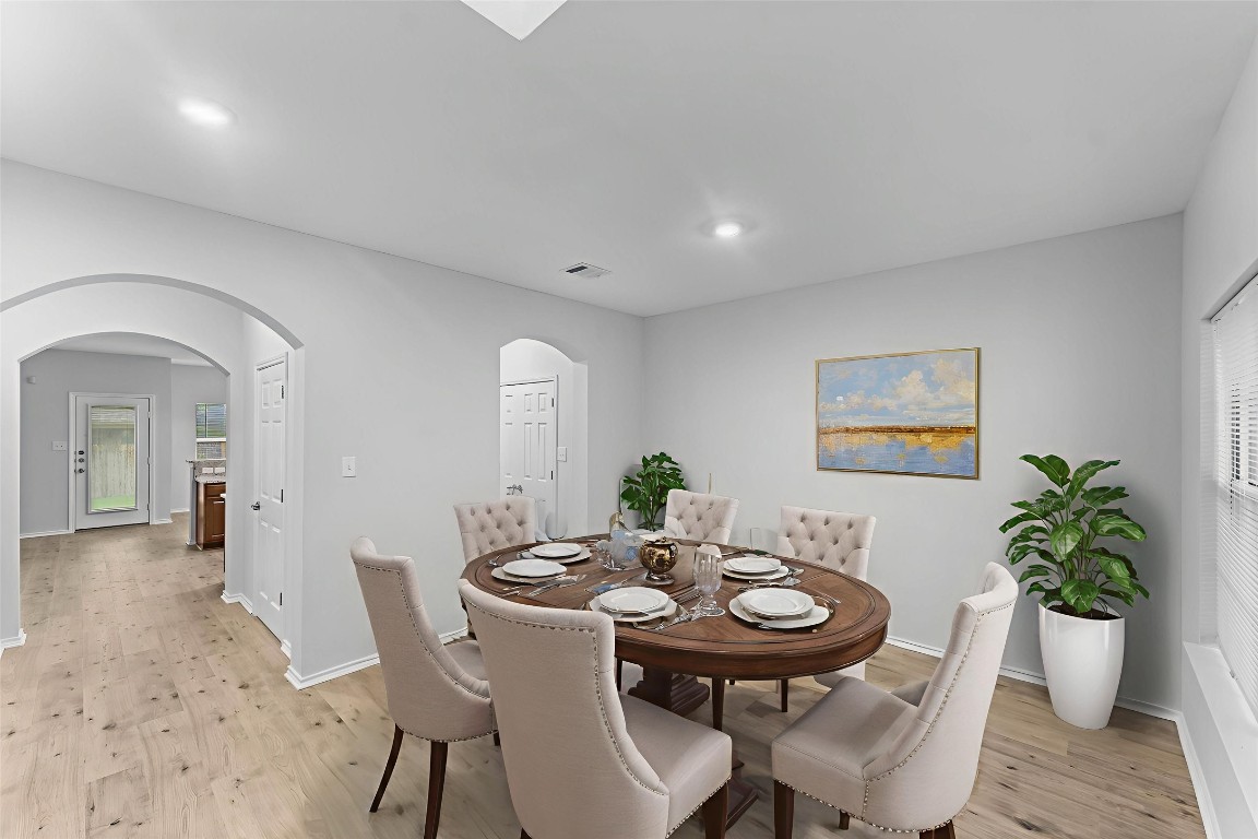 292 Housefinch Loop Leander, TX 78641 - Photo 9 of 29 Dining area with arched walkways, light wood finished floors, and recessed lighting