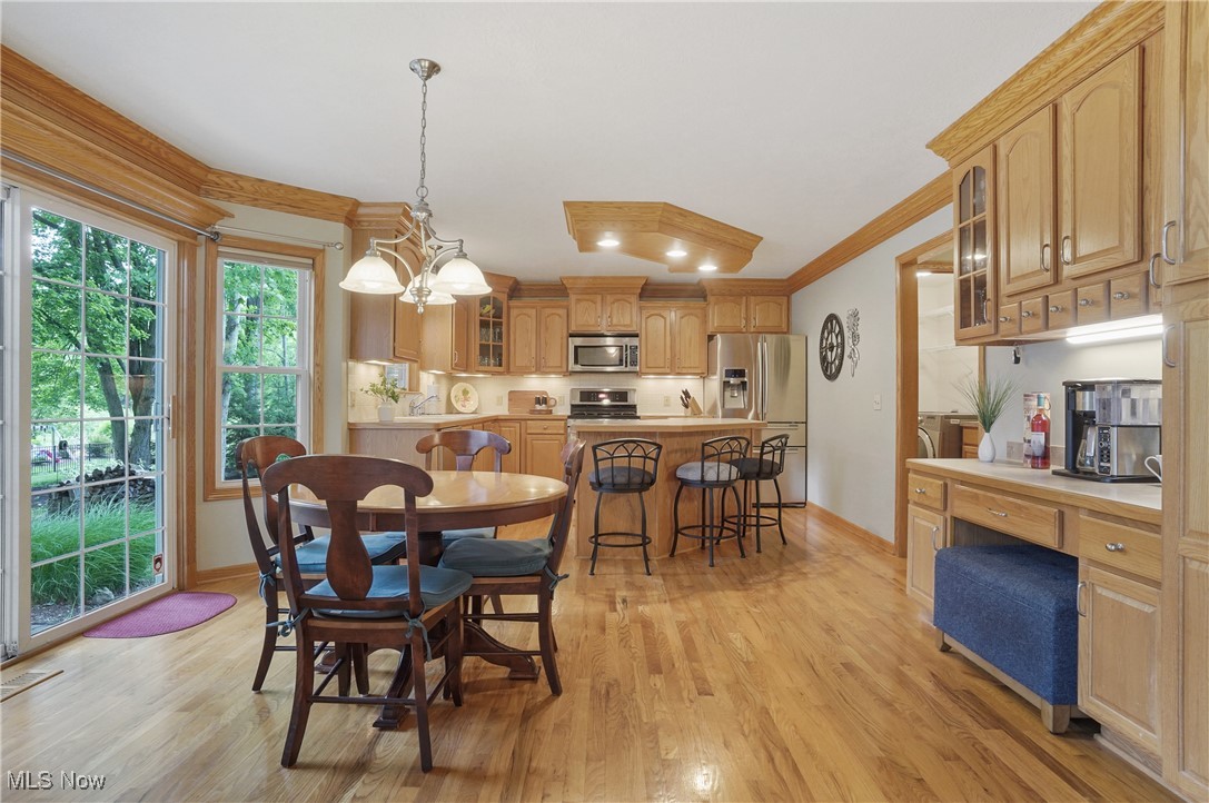 4265 Ridge Crest Drive Akron, OH 44321 - Photo 15 of 49 Dining area featuring light wood-style flooring, crown molding, and a chandelier