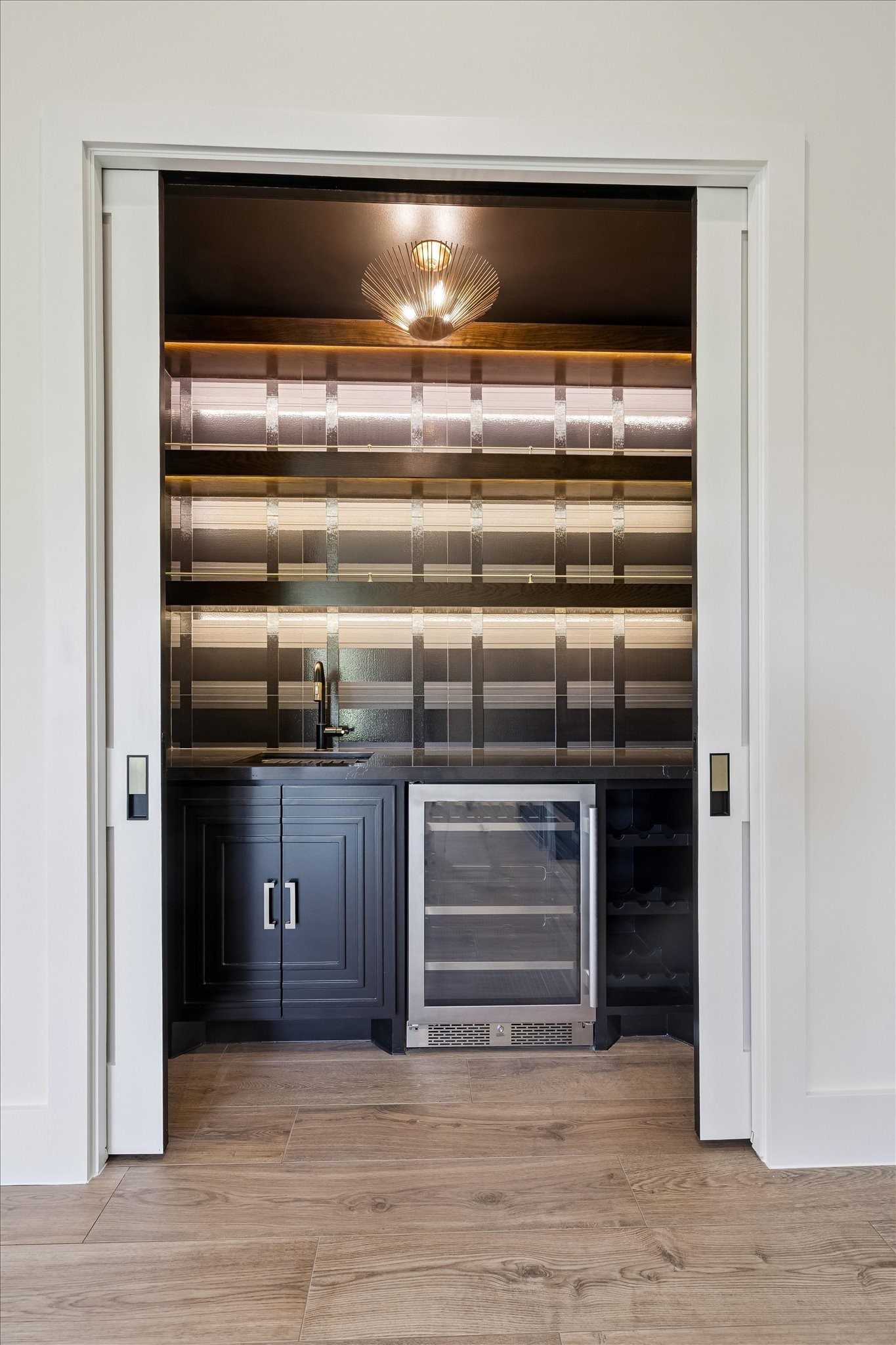 65 Shadow Creek Ridge Drive Spring, TX 77389 - Photo 9 of 41 Tucked behind sleek pocket doors, this dedicated bar area brings a boutique feel to everyday living.