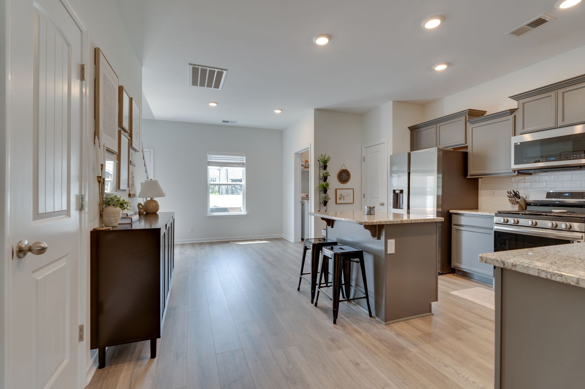 3229 Chatfield Drive Murfreesboro, TN 37129 - Photo 8 of 26 a kitchen with stainless steel appliances kitchen island granite countertop a refrigerator a stove a sink a dining table and chairs with wooden floor
