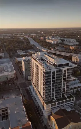 a front view of a building with glass windows and plants