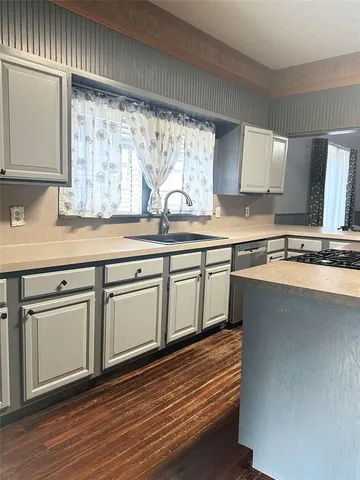 a kitchen with stainless steel appliances granite countertop a sink window and cabinets