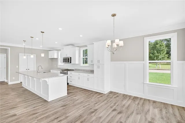 a kitchen with kitchen island granite countertop a sink and wooden floor