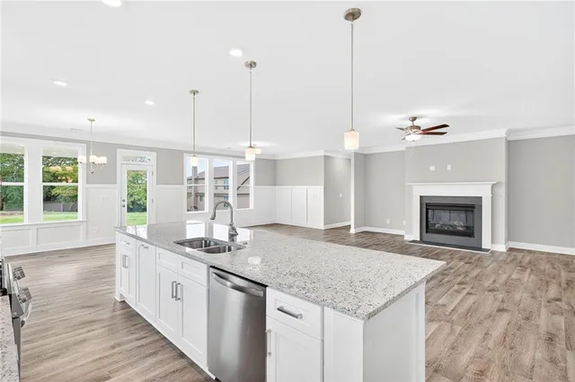 a kitchen with kitchen island granite countertop a stove and a wooden floor