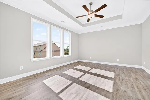 an empty room with windows and ceiling fan