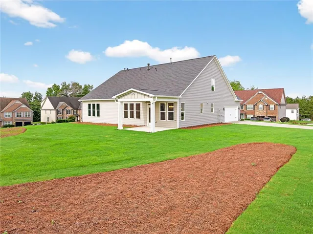 a view of a house with a big yard and large trees