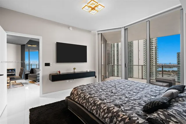 a bedroom with a large bed and a flat tv screen on dresser