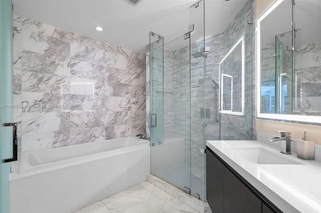 a bathroom with a granite countertop sink a toilet and shower