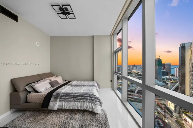 a bedroom with a bed couch and a large window