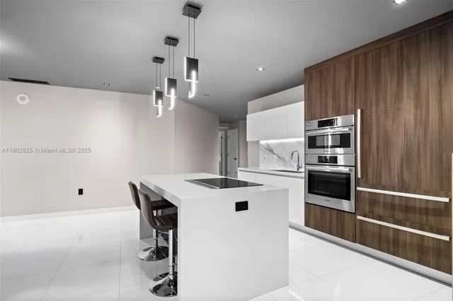 a kitchen with kitchen island a stove a sink and a refrigerator with wooden floor