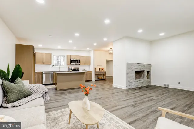 a living room with furniture kitchen view and a fireplace