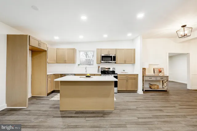 a view of kitchen with microwave stove refrigerator and cabinets
