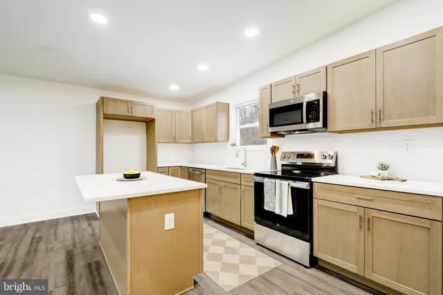 a kitchen with stainless steel appliances granite countertop a sink stove and microwave