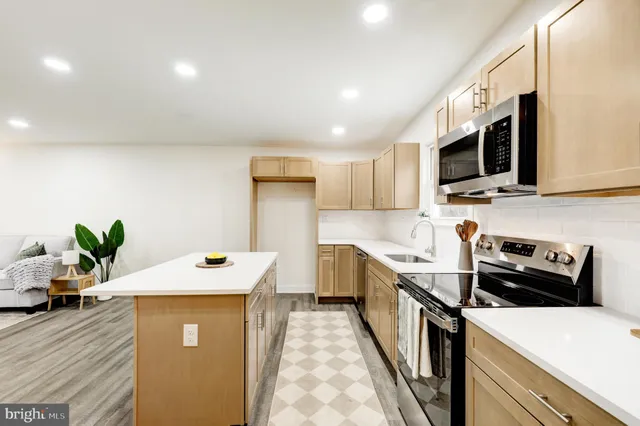 a kitchen with stainless steel appliances a stove microwave sink refrigerator and cabinets