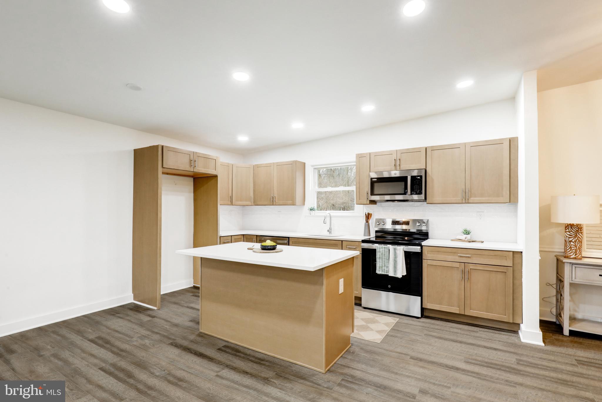 904 South Chester Road West Chester, PA 19382 - Photo 24 of 47 a kitchen with stainless steel appliances granite countertop a stove top oven a sink dishwasher and a refrigerator with wooden floor