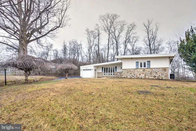 a front view of a house with a yard and trees