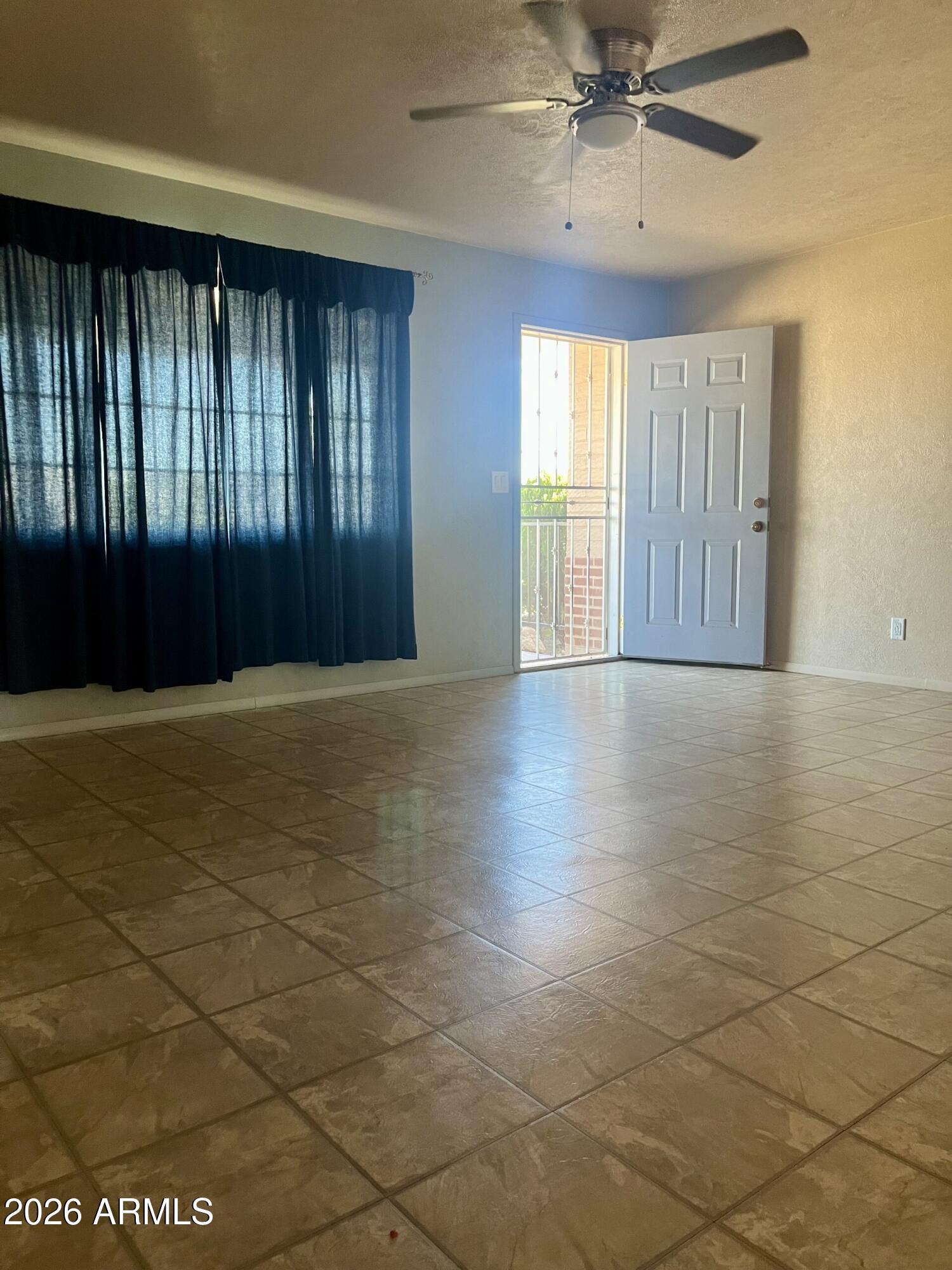 2315 West Butler Drive Phoenix, AZ 85021 - Photo 2 of 13 an empty room with windows and fan