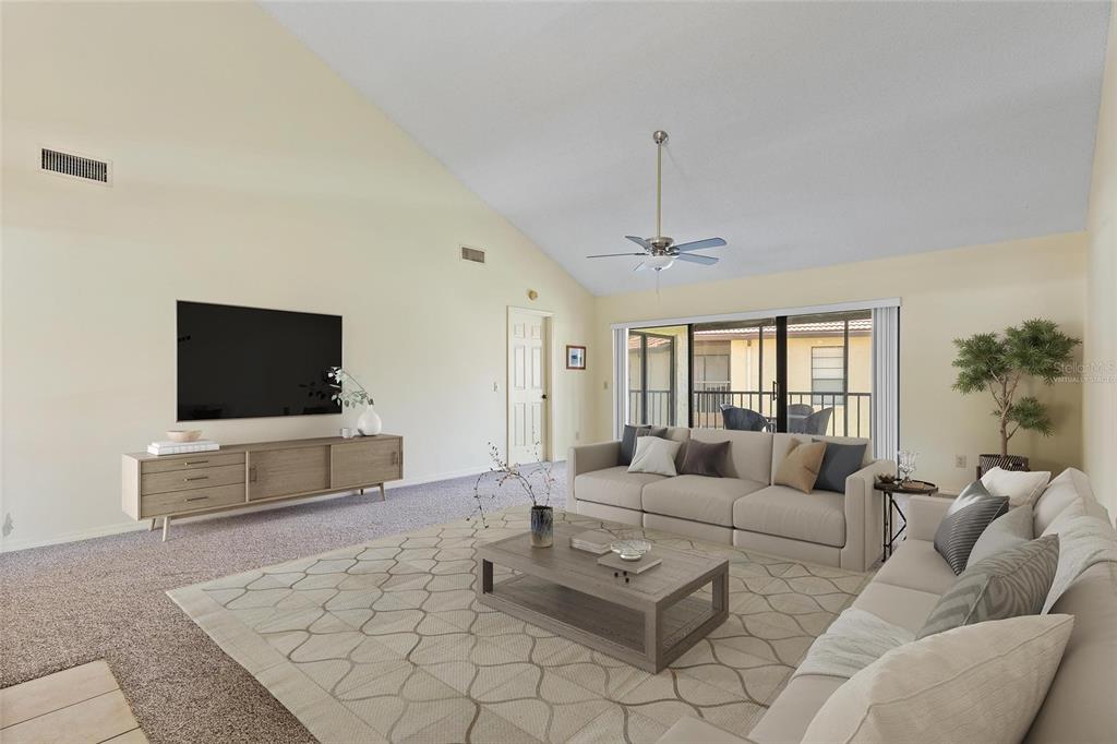1801 East Lake Road South, Unit 4E Palm Harbor, FL 34685 - Photo 9 of 26 a living room with furniture and a flat screen tv